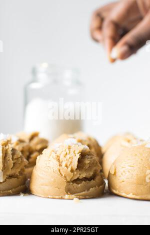 Pelles de pâte à biscuit à la vanille sur un plateau doublé de parchemin, pâte à biscuit à la vanille simple avec des flocons de sel sur le point d'être cuits Banque D'Images