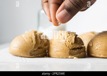 Pelles de pâte à biscuit à la vanille sur un plateau doublé de parchemin, pâte à biscuit à la vanille simple avec des flocons de sel sur le point d'être cuits Banque D'Images