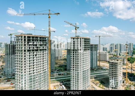nouveaux immeubles d'appartements à plusieurs étages en construction avec grues sur le chantier. photo de drone aérien. Banque D'Images