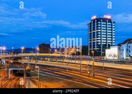 Bâle, Suisse - 23 août. 2021: Gare de Bâle la nuit avec la boîte centrale de signalisation du chemin de fer fédéral suisse en arrière-plan. Banque D'Images