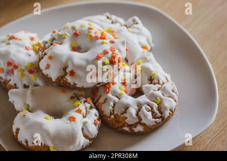 Une assiette de sucreries avec glaçage blanc, saupoudrés rouges jaunes Donuts faits maison, rosquillas, beignets traditionnels anis d'Espagne typiquement mangés à Pâques Banque D'Images