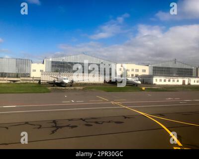 Deux gros avions rapides blancs puissants sont garés près des hangars de l'avion sur la piste. Banque D'Images