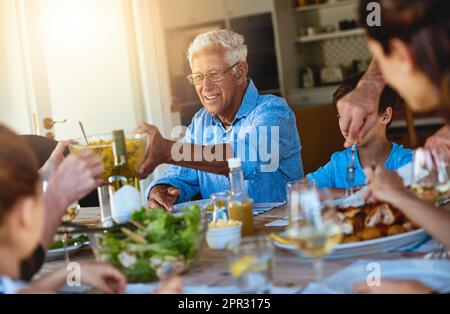 Theres plus que suffisant pour tout le monde. une famille heureuse en train de déjeuner autour d'une table à l'extérieur. Banque D'Images