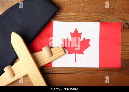 Drapeau du Canada avec chapeau d'hôtesse et jouet d'avion sur fond de bois, gros plan Banque D'Images