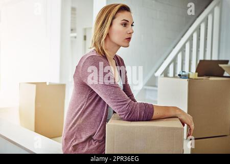 Suis-je vraiment en train de passer à des choses meilleures et plus grandes. une femme qui a l'air attentionnés tout en déménagent. Banque D'Images