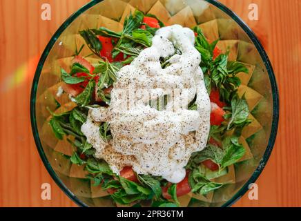 Bol de salade frais à base de podagraria frais d'Aepopodium communément appelé aîné de terre, herbe gerard, herbe d'évêque, feuilles de moût de goutte, tomate, concombre Banque D'Images