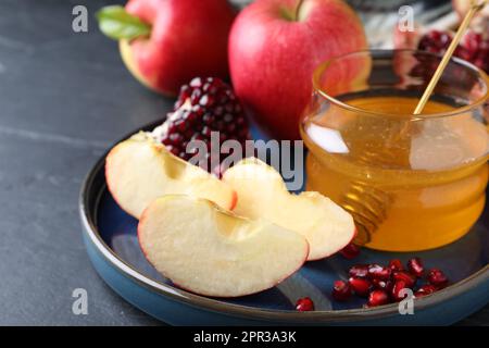 Miel, grenade et pommes sur table noire, gros plan. Rosh Hashana vacances Banque D'Images