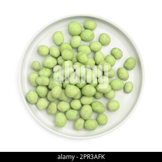 Assiette avec arachides recouvertes de wasabi sur fond blanc, vue de dessus Banque D'Images