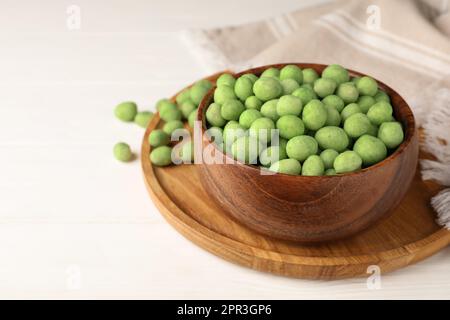 Savoureux arachides enrobées de wasabi sur table en bois blanc, espace pour le texte Banque D'Images