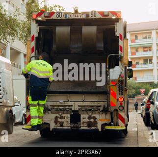 Lion, France - 14.10.2017 : deux employés chargés de la collecte des déchets chargent des déchets dans des conteneurs de vidange de camions de déchets Banque D'Images