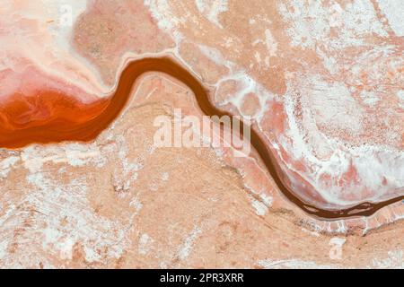 Vue aérienne d'un ruisseau d'eau rouge qui traverse un bassin sec de lac salé à Sealake, à Victoria, en Australie Banque D'Images