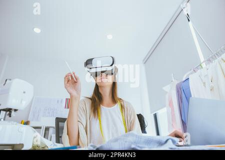 Concepteur de costumes utilisant la technologie moderne de conception numérique visuelle VR dans un studio sur mesure Banque D'Images