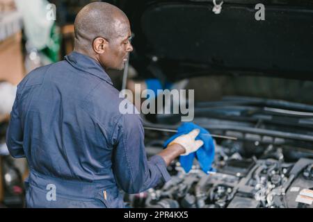 Garage mécanicien Africain Noir homme professionnel automobile service de travail vérification de l'huile moteur Banque D'Images