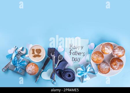 Carte de vœux de fête des pères. Petit-déjeuner le matin de la fête des pères avec un arrière-plan de surprise mignon, des boîtes-cadeaux, des petits gâteaux, une tasse de café, un décor de coeur, Banque D'Images