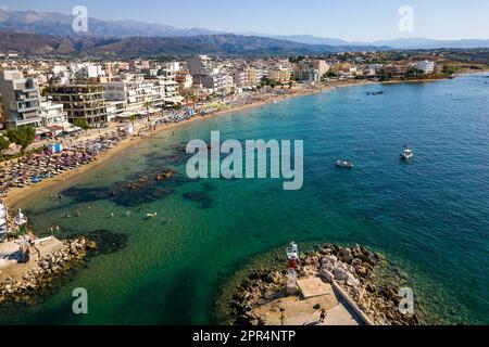 Vue aérienne d'une plage animée dans la station balnéaire populaire de Nea Chora à Chania, Crète (Grèce) Banque D'Images