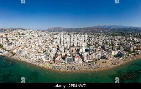 Vue aérienne d'une plage animée dans la station balnéaire populaire de Nea Chora à Chania, Crète (Grèce) Banque D'Images