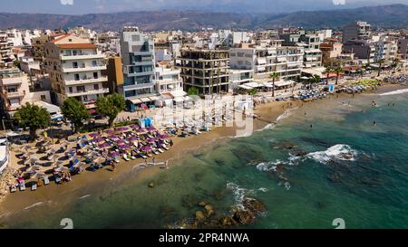 Vue aérienne d'une plage animée dans la station balnéaire populaire de Nea Chora à Chania, Crète (Grèce) Banque D'Images