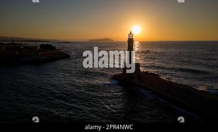 Coucher de soleil derrière un vieux phare en pierre dans la ville grecque de Chania, Crète Banque D'Images