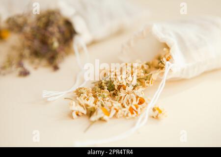 herbes séchées dans des sacs blancs de coton par le dessus. Sachets remplis de chamomilla médicinales et de petits pains Banque D'Images