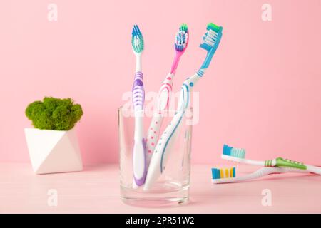 Brosses à dents en verre sur fond rose outils pour soins buccaux. Vue de dessus Banque D'Images