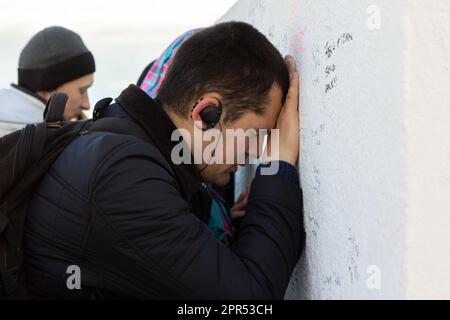 Un pèlerin dans une profonde prière au pied de la croix sur le mont Križevac à Medjugorje. Banque D'Images