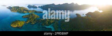 La lumière du matin brille sur les spectaculaires îles de calcaire qui s'élèvent du paysage marin magnifique, biodiversifié et varié de Raja Ampat. Banque D'Images