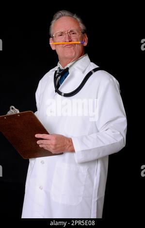 Médecin senior portant un stéthoscope isolé et s'amusant avec un crayon sur sa lèvre Banque D'Images
