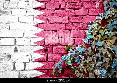 Le Qatar grunge le drapeau sur le mur de brique avec l'usine de lierre, symbole de pays concept Banque D'Images