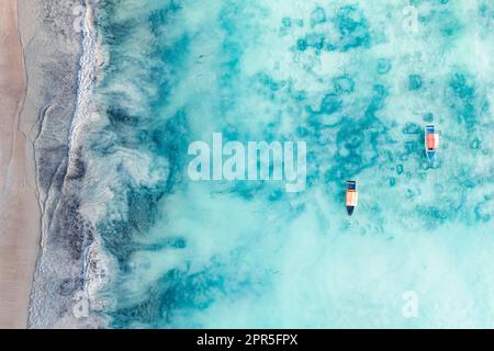 Vue aérienne des bateaux dans l'eau cristalline de l'océan Indien à proximité d'une plage tropicale vide, Zanzibar, Tanzanie Banque D'Images