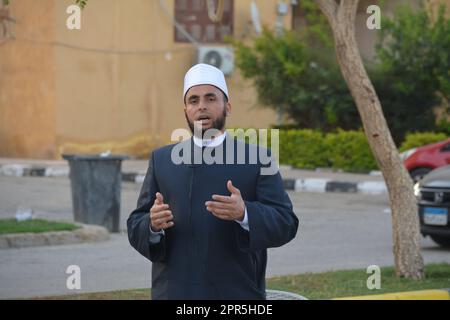 Le Caire, l'Egypte, le 21 avril 2023: Un imam prédicateur de mosquée interprète Eid Al Fetr Khutbah (sermon) dans un espace en plein air près de la mosquée, les feas de petit déjeuner islamique Banque D'Images