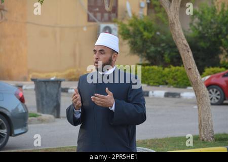 Le Caire, l'Egypte, le 21 avril 2023: Un imam prédicateur de mosquée interprète Eid Al Fetr Khutbah (sermon) dans un espace en plein air près de la mosquée, les feas de petit déjeuner islamique Banque D'Images