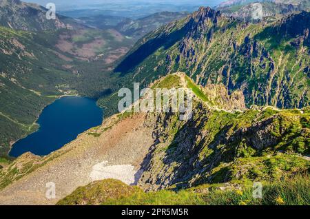 Lac et crête dans les montagnes polonaises dans les paysages d'été. Morskie Oko (oeil de la mer) et sentier menant par une section de crête exposée, appelée Kazalnica, Hi Banque D'Images