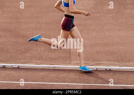 jeune femme mince, course à pied à mi-distance au stade lors des championnats d'athlétisme d'été Banque D'Images