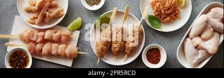 Diverses viandes de poulet non cuites sur une surface grise Banque D'Images