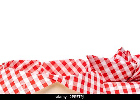 Gros plan d'un panier de paille vide avec une serviette à carreaux rouges et un navire plié isolé sur un fond blanc. Pour le montage de vos produits alimentaires. Macro. Banque D'Images