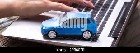 Petite voiture bleue sur le clavier de l'ordinateur portable Banque D'Images