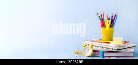 Beaucoup de diverses écoles, fournitures de bureau sur une table en bois sur fond vert Banque D'Images