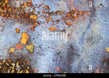 Carburant et huile colorés sur une texture d'asphalte montrant une forte pollution environnementale. Banque D'Images