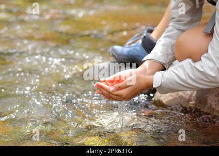 Femme a attrapé les mains qui attrapent l'eau de la rivière Banque D'Images