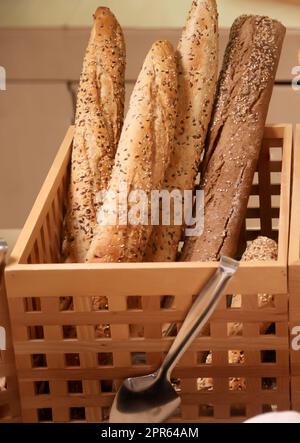 Plusieurs pains de pain, baguettes se tiennent à l'extrémité dans le panier en bois. Banque D'Images