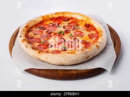 Vue de dessus de pizza chaude sur un stand en bois. Banque D'Images