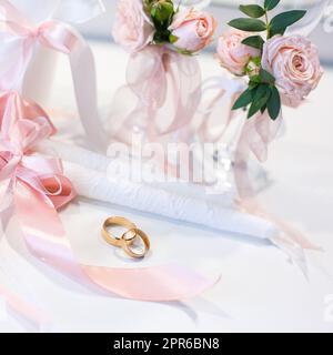 Des anneaux de mariage dorés sont installés sur la table près des bougies de mariage. Banque D'Images