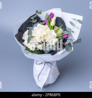 Délicat bouquet romantique de fleurs enveloppé de papier blanc. Banque D'Images