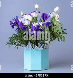 Bouquet lumineux original avec eustoma blanc sur fond bleu. Banque D'Images