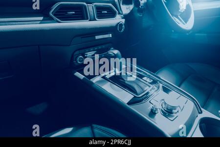 Intérieur de voiture moderne et luxueux. Intérieur de la voiture au design moderne. Levier de vitesses automatique. Sièges en cuir noir et confortable d'une nouvelle voiture. Cockpit en cuir. Boîte de vitesses, volant, tableau de bord, bouton de commande de climatisation Banque D'Images