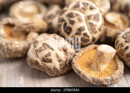 Champignons shiitake séchés sur fond en bois.Une alimentation saine. Banque D'Images