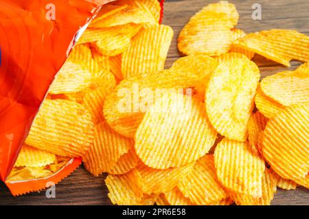 Croustilles dans un sac ouvert, délicieux assaisonnement barbecue épicé pour les pleurs, fine tranche de collation frite rapide. Banque D'Images