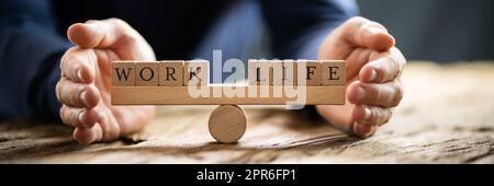 Couvrant la main Équilibre entre vie et travail sur Seesaw Banque D'Images