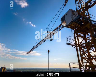 Grue de construction sur l'arrière-plan d'une vue aérienne ciel clair de jour. Survol d'une grue de construction sur un quadricoptère sur le fond d'un ciel bleu épique avec le soleil, gros plan Banque D'Images