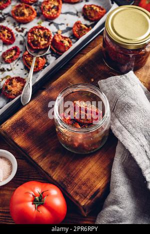 Conservation des tomates séchées au soleil avec le thym dans un pot Banque D'Images